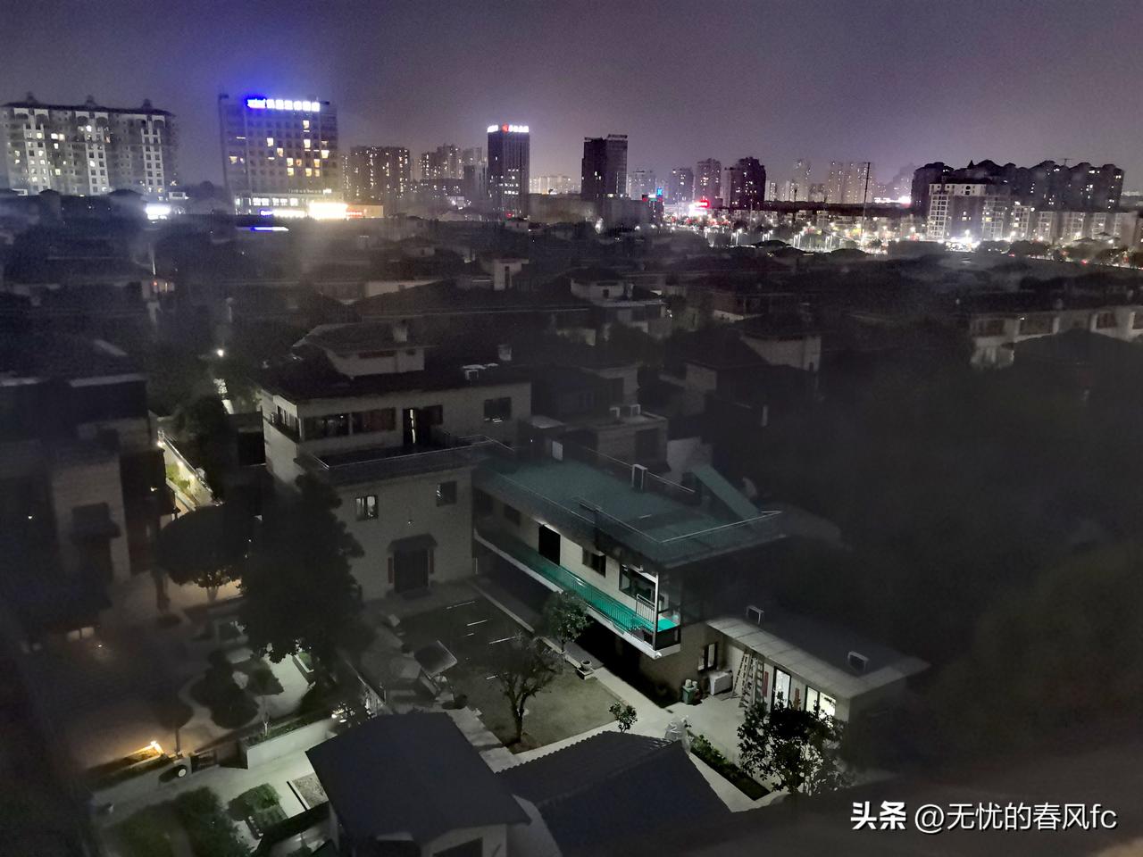 夜光下的高楼大厦与别墅，一大片别墅，就一栋别墅的门卫亮着灯，好凄凉，像城中突然冒