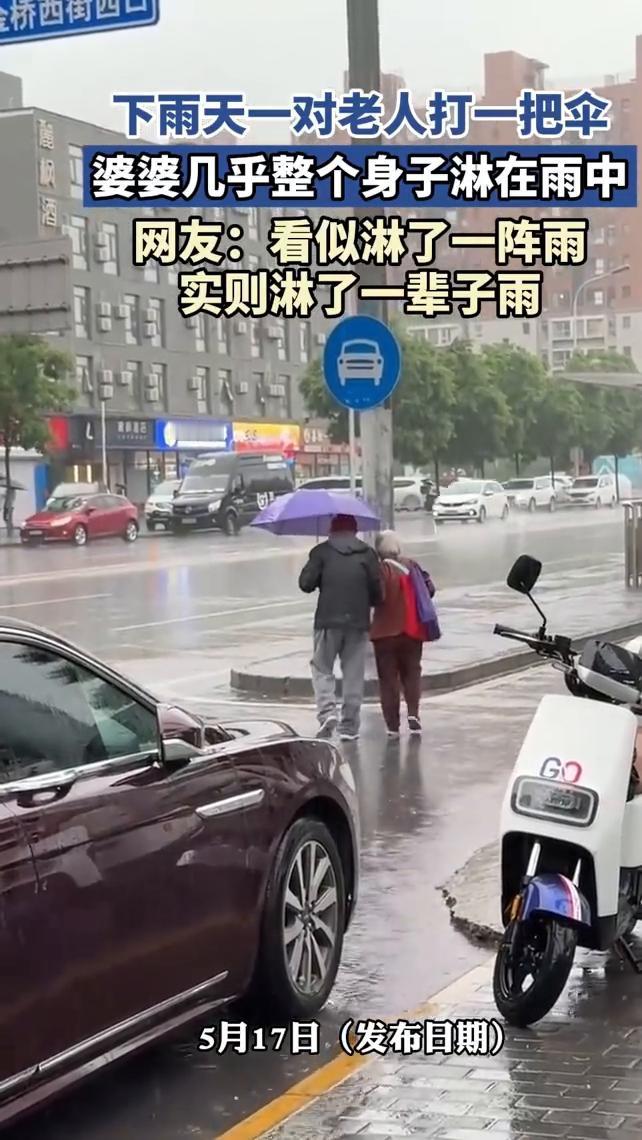 下雨天一对老人打一把伞，婆婆几乎整个身子淋在雨中。
网友：看似淋了一阵雨，实则淋