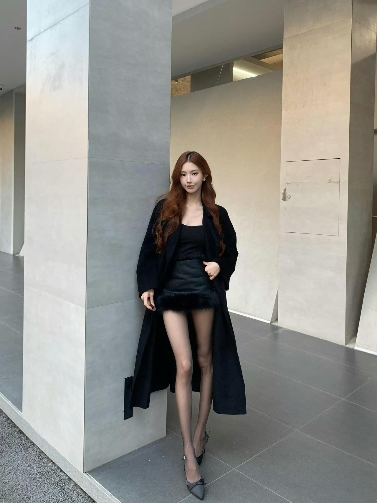 这套穿搭太有“冷艳贵气感”了！黑色长款大衣自带气场，皮裙的毛绒边添了精致细节，搭