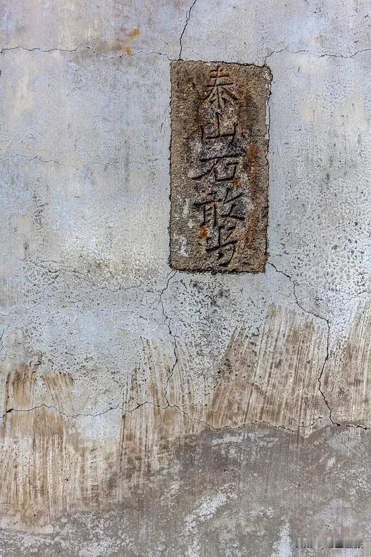 前阵子回村走亲戚，还看见老李家新盖的自建房西北角，嵌了块半米高的青条石，上面刻着