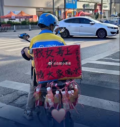 闪送员车上挂饮料庆祝女儿考上北大闪送师傅女儿喜提北大录取通知书，骑车沿路赠水分享