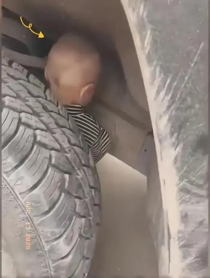 一位大货车司机拍下照片，在他准备启动自己的大货车离开的时候，发现一名小男孩竟然躲