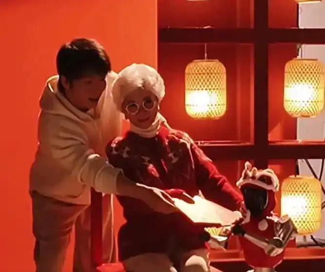 春晚官方发布的最新视频里，蔡明时隔七年再度亮相，和“喜人”王天放以及机器人一起拍