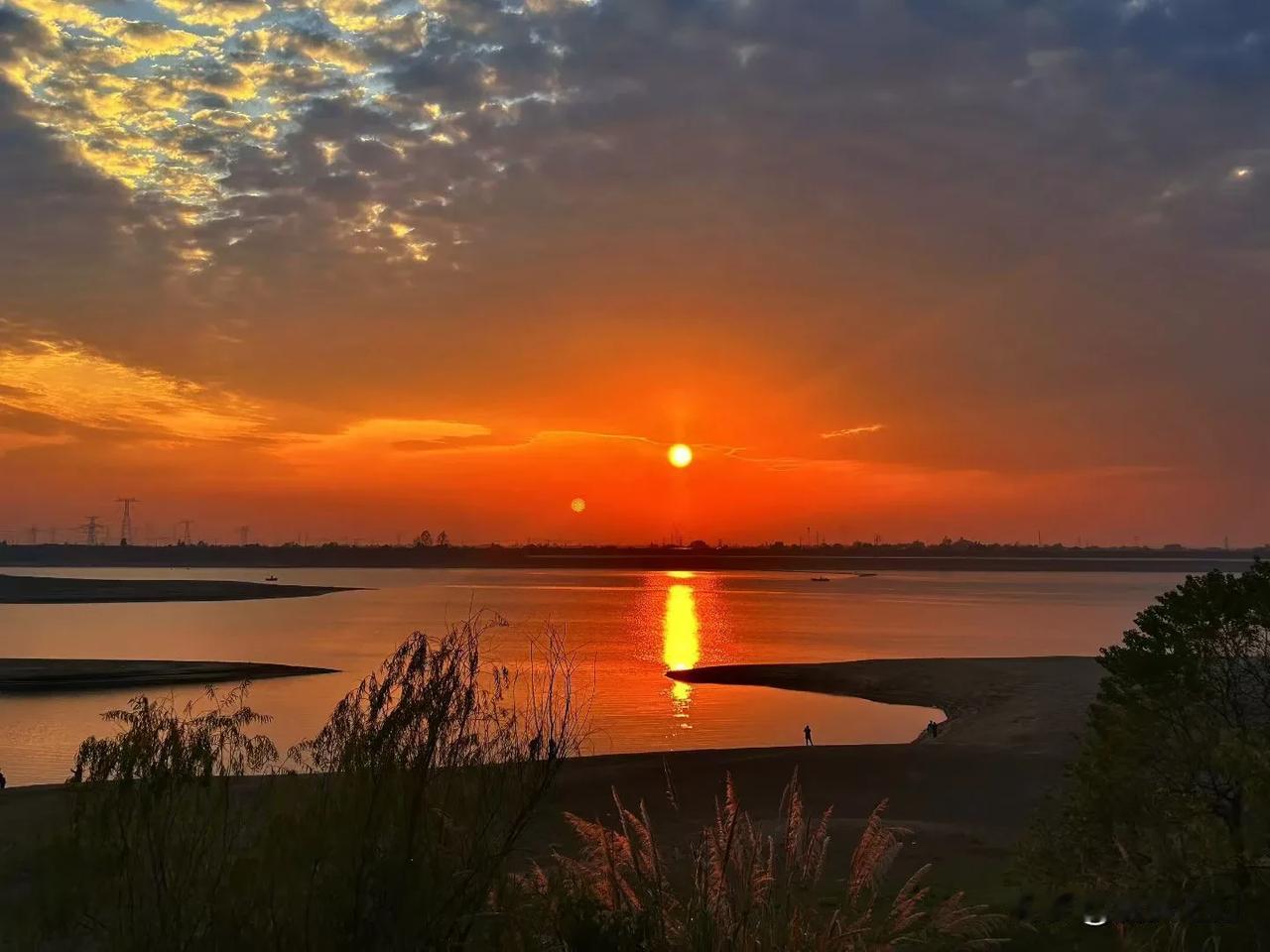 《临江仙·江畔霞辉》
霞染长天铺锦绣，金波碎落汀洲。双轮夕照逐轻舟。苇风梳岸柳，