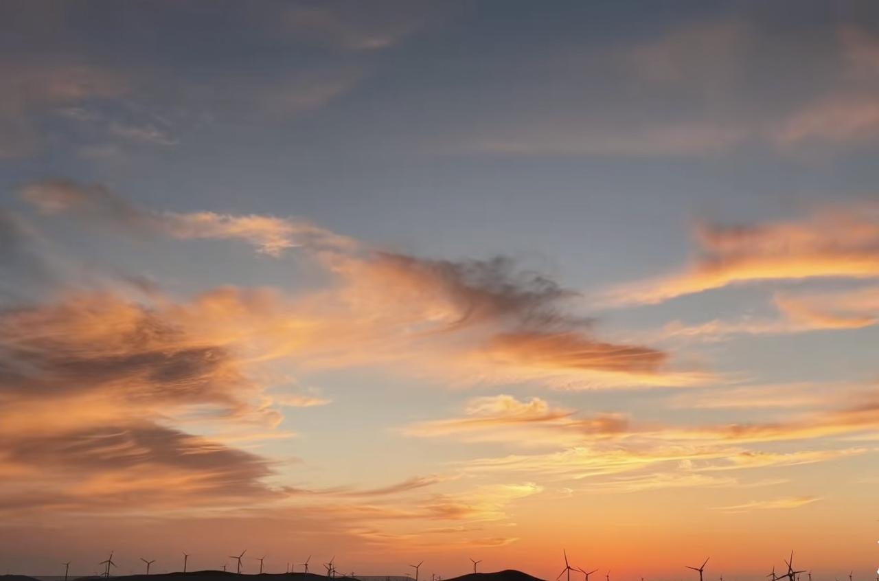 天空像打翻的调色盘，橙红色晚霞占了大半，浓烈似天空在燃烧。边缘是淡淡粉色，像少女