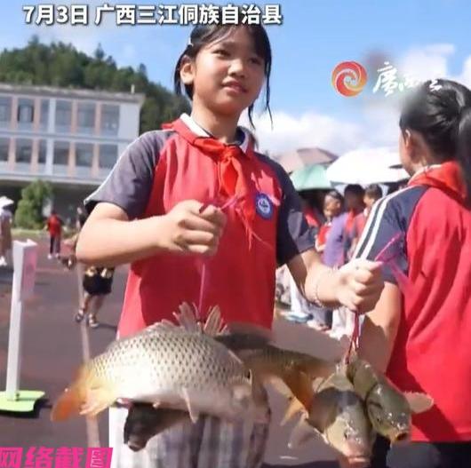 广西某地中心小学在暑期迎来的放假典礼上，这一刻颁发给学生们不是奖状而是大鱼，学校