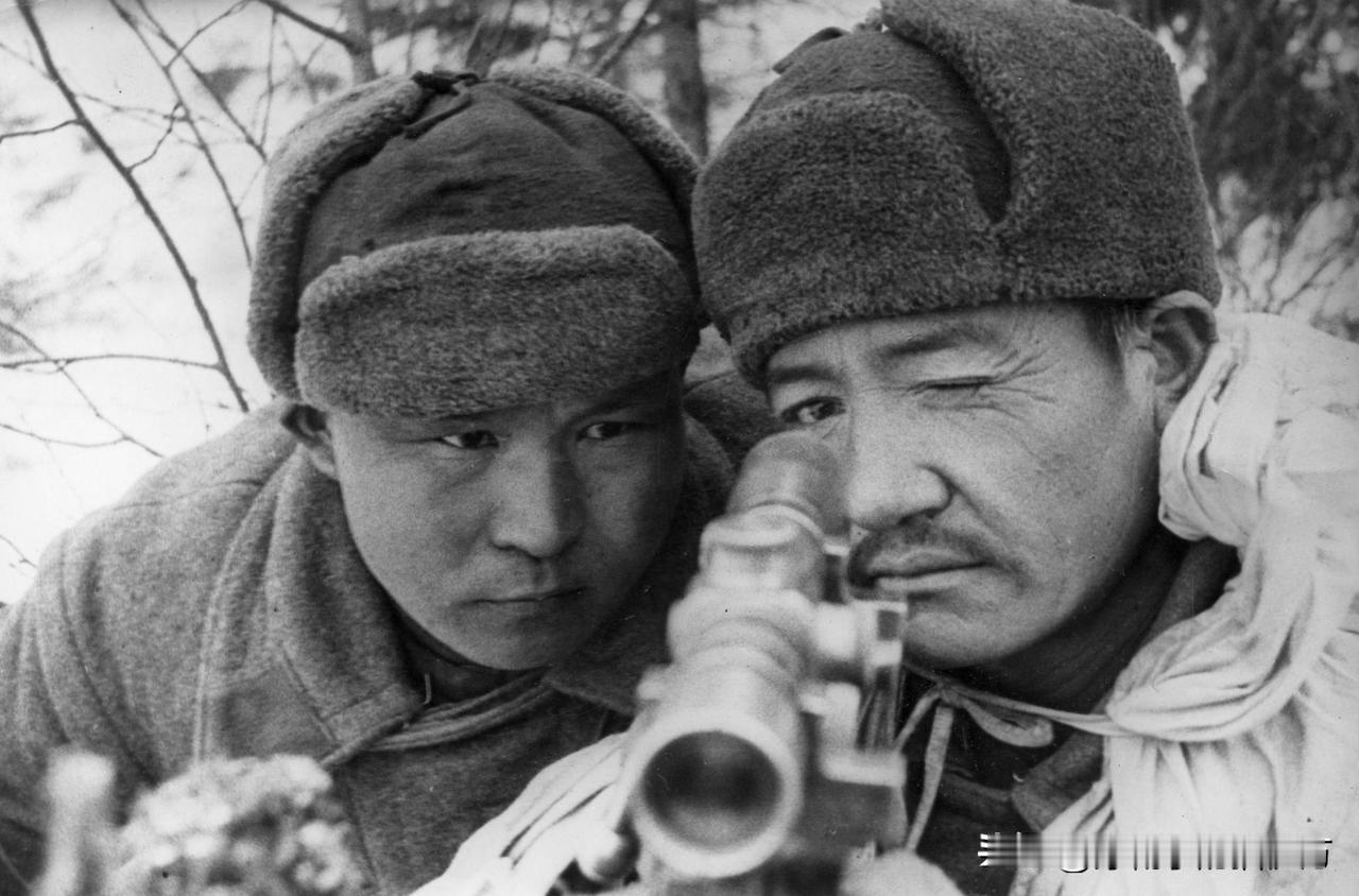 卫国战争时期，狙击手西亚兹别科夫（右）亲自示范，教授学员狙击技巧。从照片中可以看