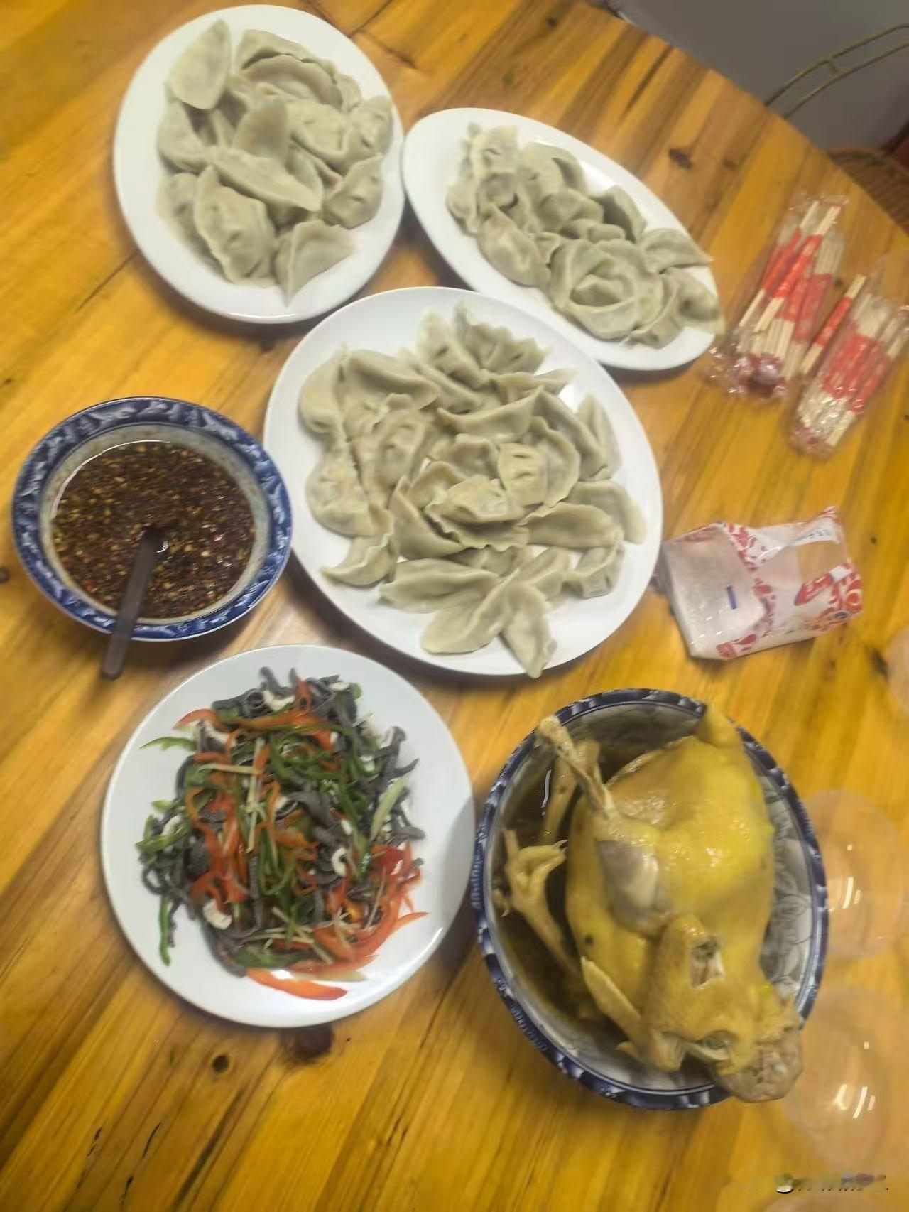 今天这饭可太顶了！一桌子饺子堆得冒尖，还有整只的白斩鸡，配着凉拌木耳脆生生的，蘸