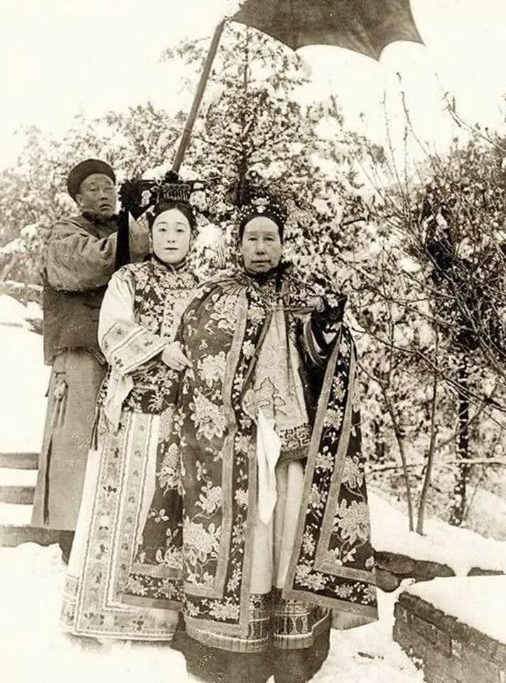 慈禧皇后与她的侄女在北京故宫花园。撑伞的是李莲英。