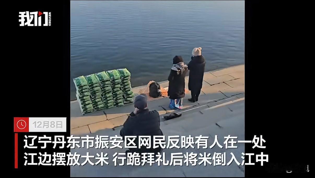 丹东鸭绿江边，一群人把整袋整袋的大米倒进江里，旁边还有人跪拜。

根据新京报的报