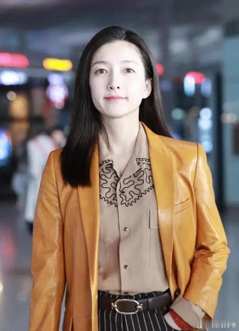 江疏影果然是穿搭高手！一件橘色皮衣内搭衬衫，下身搭配条纹西裤，整体造型既时髦又透