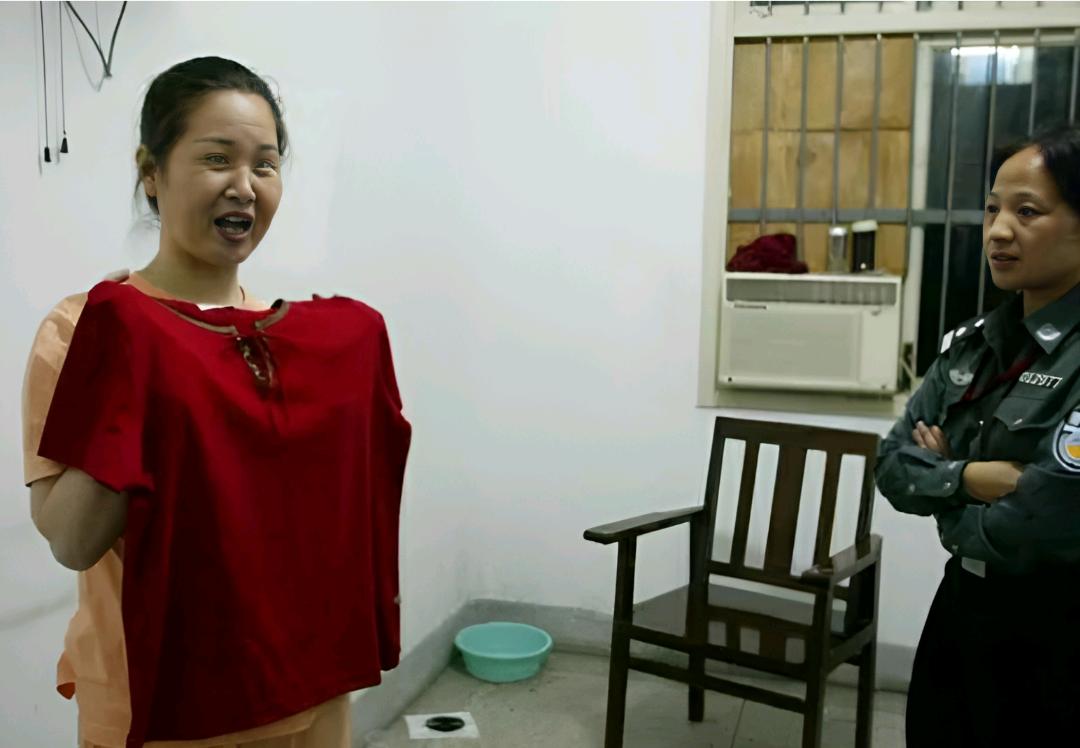 2003年6月，死刑犯代冬梅拿着狱警给她买来的新衣服，显得非常开心，正在准备试穿