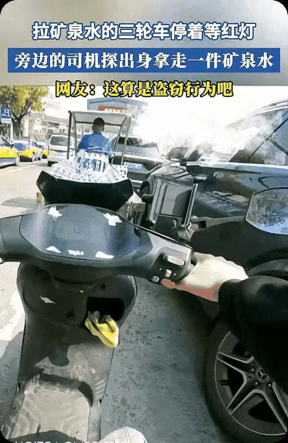 路口等红灯时，你见过这样的场景吗？一辆满载矿泉水的三轮车旁，突然停下一辆奔驰，接