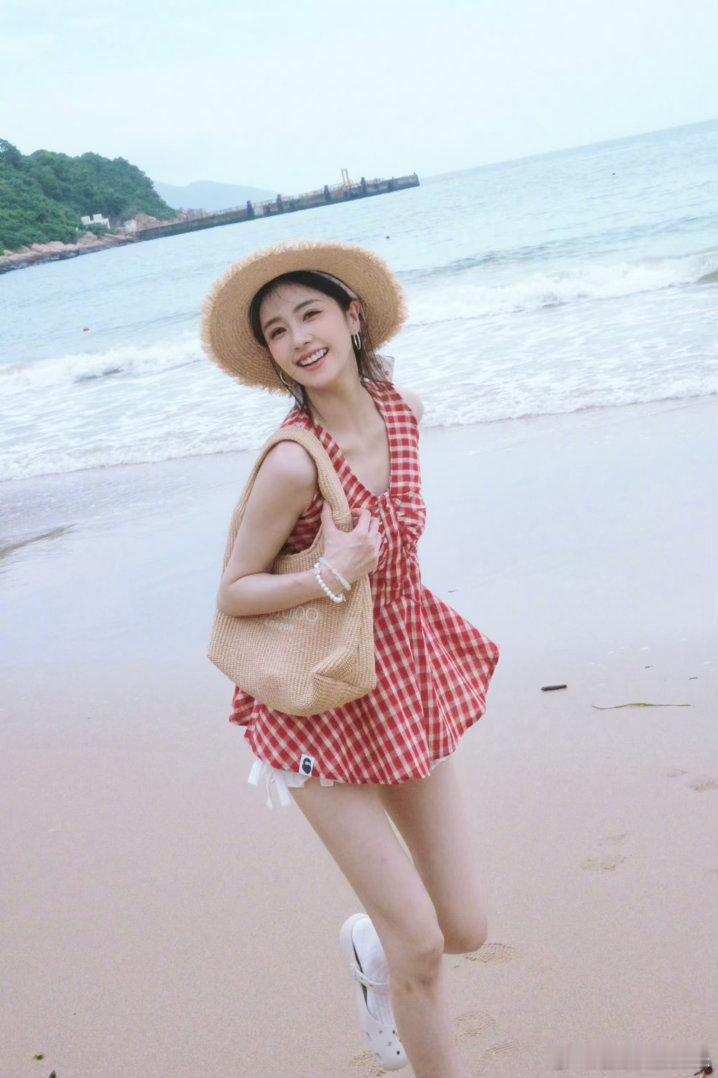 白鹿海边度假照片里的白鹿一身轻松休闲穿搭，漫步在海边，蓝天、白云、沙滩、海浪作背