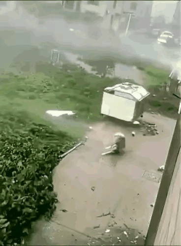 狂风暴雨之间，男子开着车在路上行驶的时候，突然看到天空中有一条狗，从自己的车窗玻