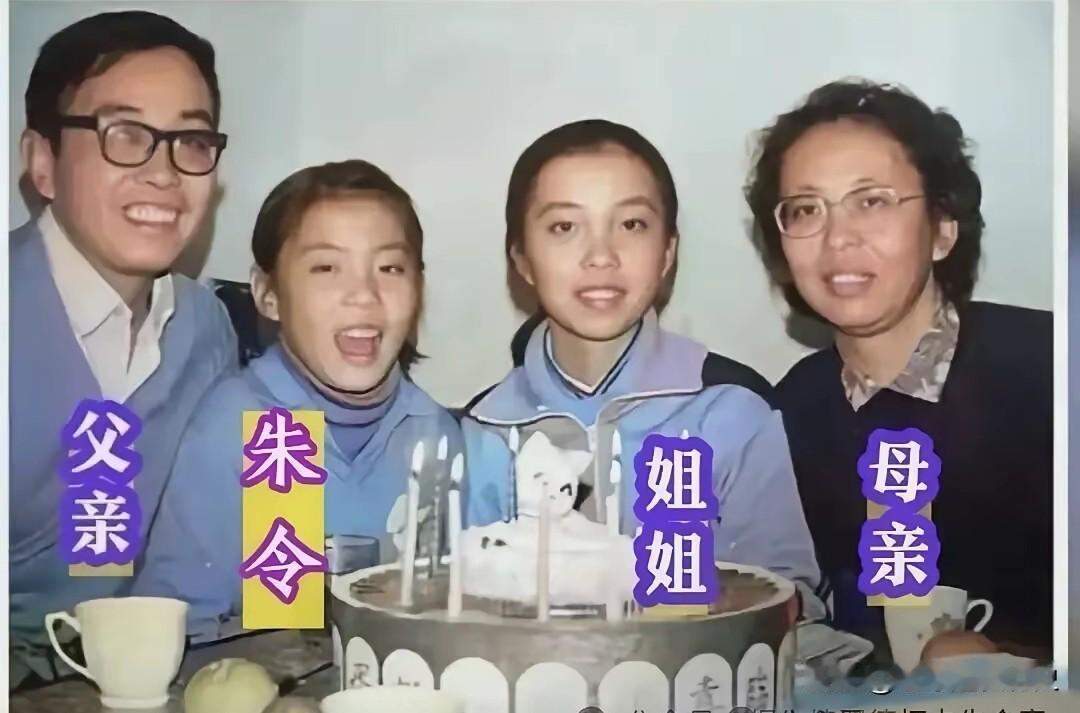 这是朱令早年家庭生日时温馨的留影。
画面中，父母温和含笑，姐姐端庄恬静，朱令活泼