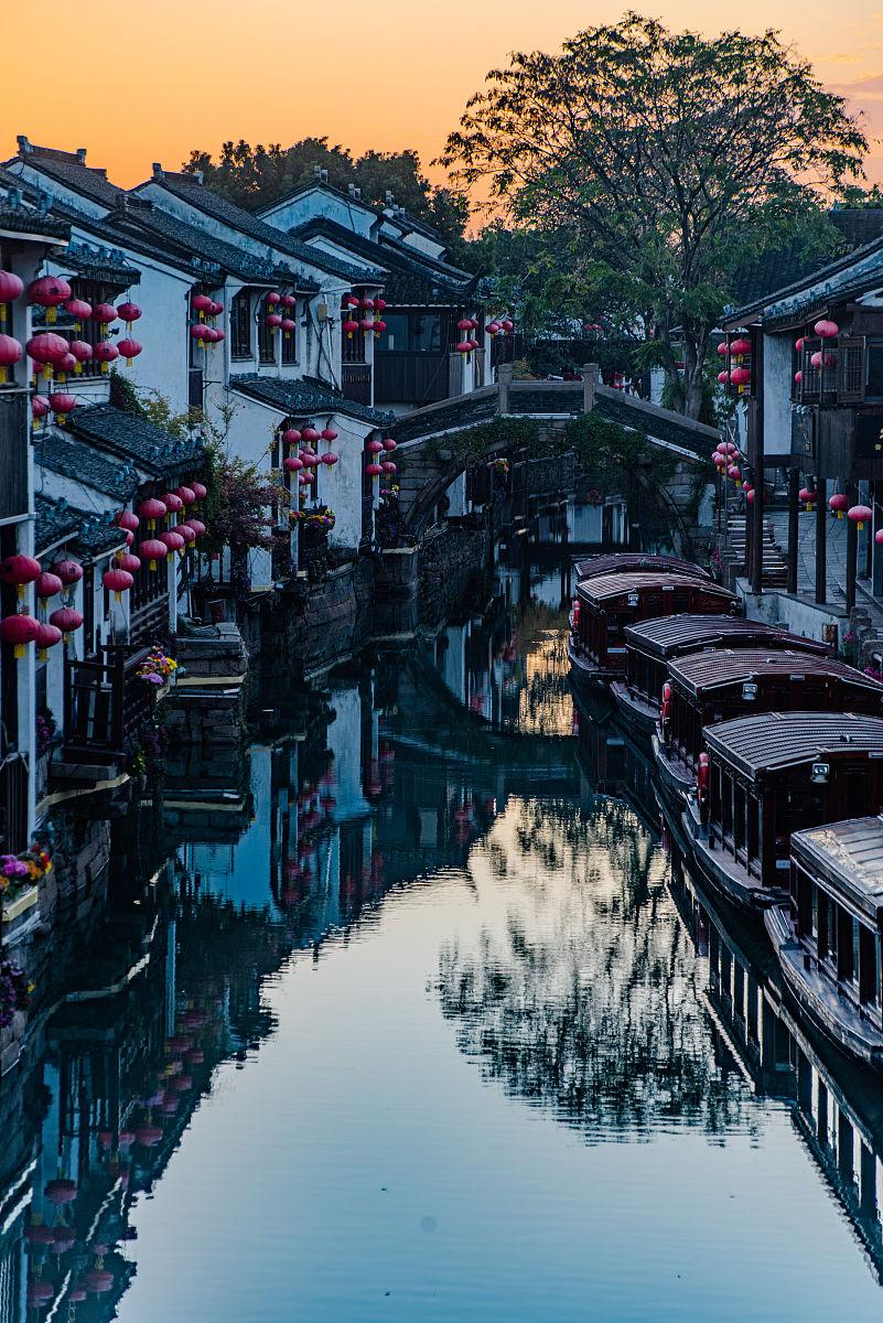 苏州是浸在烟雨里的双面绣，一边是平江路青石板载着的千年姑苏梦，拙政园的漏窗漏过唐
