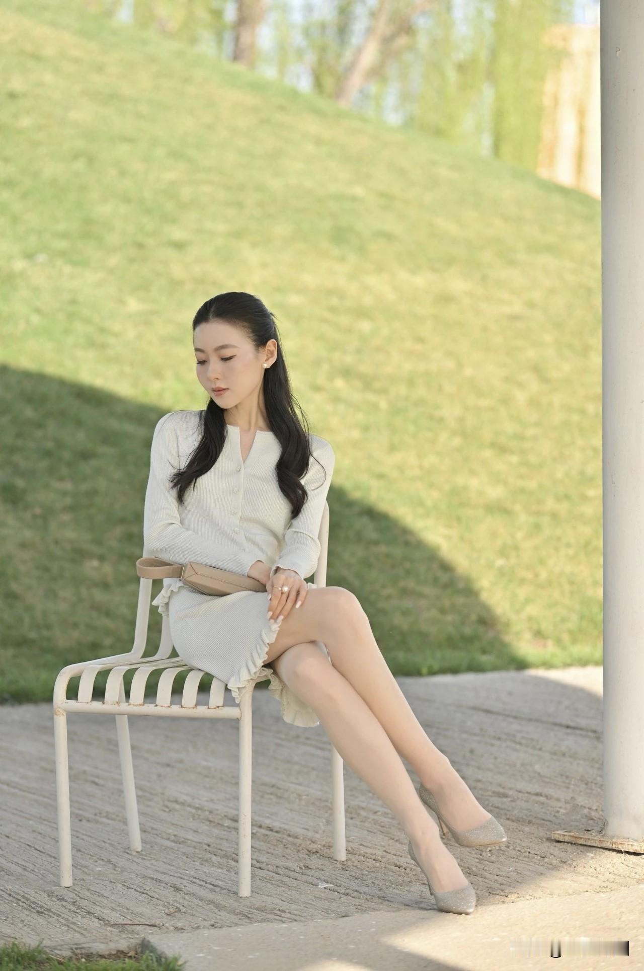 午后时光，最适合在优雅坐椅间静静享受。就像阿琳，一袭浅绿吊带长裙，在郊外林地美得