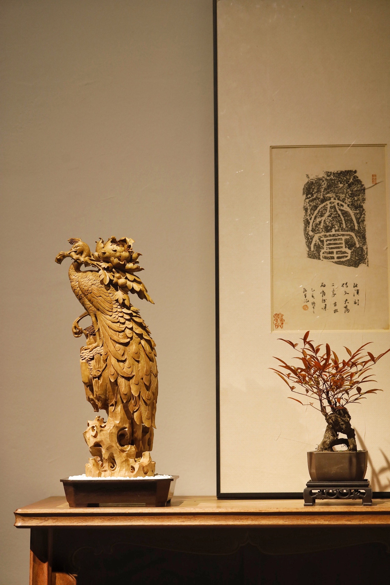 老山檀香｜富贵吉祥·案摆檀香肌理凝润，整料雕孔雀立崖：孔雀首衔花枝，背拥牡丹团簇