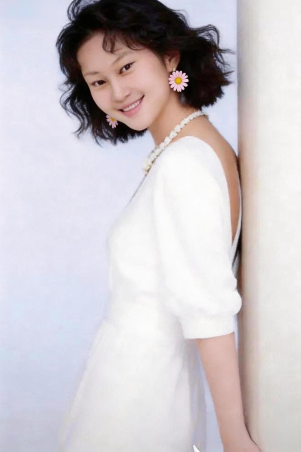 这位美女穿着白裙，笑得真甜。