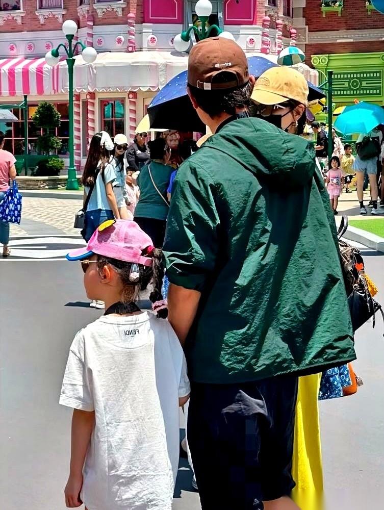 传了一年婚变，结果在新加坡环球影城，有人的手机镜头里，扫到了一个穿绿色冲锋衣的男