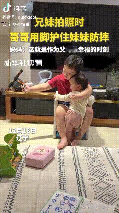 省心了！辽宁，哥哥搂着妹妹拍照，哥哥害怕妹妹站不稳还专门用脚勾着妹妹，孩子妈妈表