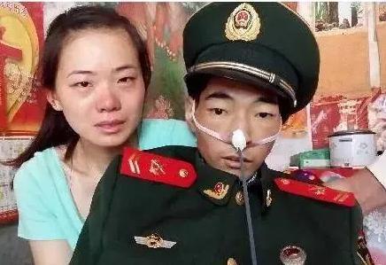 照片上的这个人身穿军装，骨瘦如柴，他此刻强打起精神，与妻子一起拍下了人生中最后的