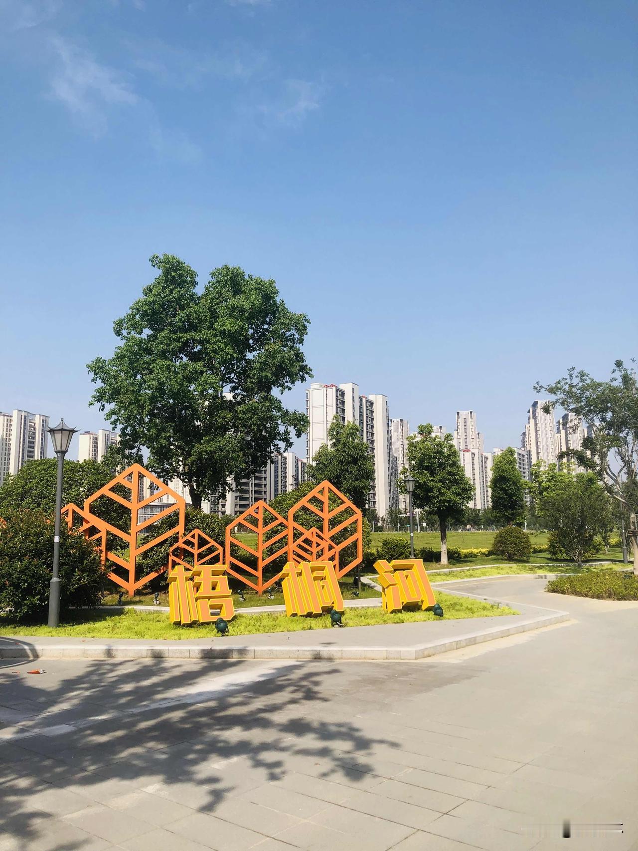 闲暇之余逛逛梧桐河随手拍下沿路美丽的风景，晴空衬着成片绿树，河道清悠悠绕着居民区