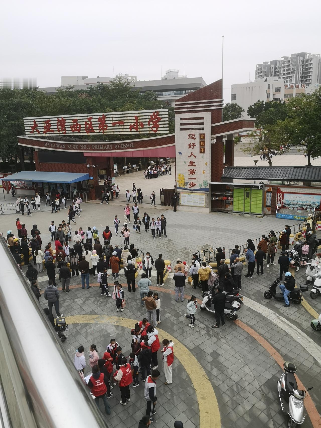 大亚湾西区第一小学中午放学时间，学校门口围满了接孩子的家长和学生。
现在的学校，