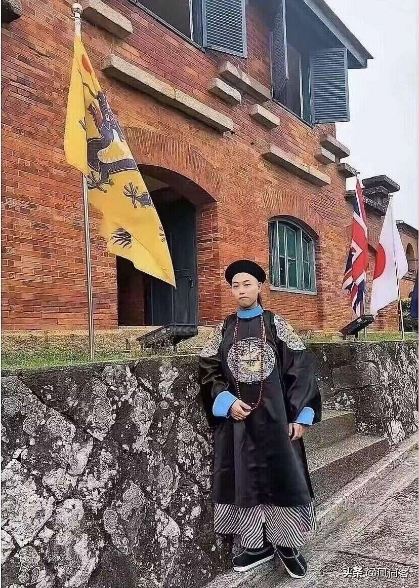 当博主身着清代官服站在同时竖有清代黄龙旗、近代英国旗与日本旗的建筑前，配文抒发“