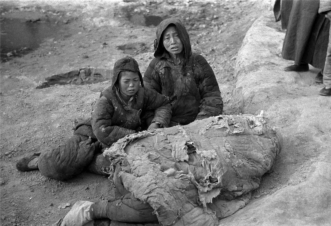 1942年河南大饥荒的一幕，破旧棉被下掩盖的是男人的遗体，他被活活饿死，留下了孤