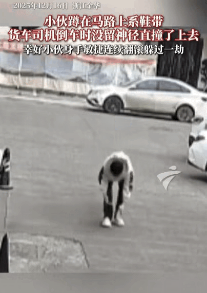 浙江，小伙蹲马路上系鞋带，结果，刚起身，就迎面碰上倒车的货车，小伙瞬间被撞翻，幸