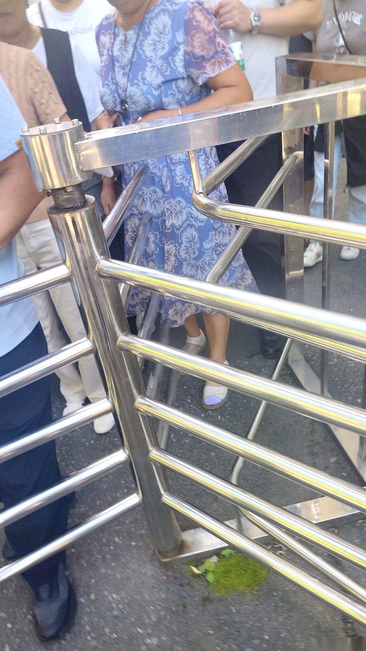一个4A景区出口，乌泱泱挤满了人。往前探头一看，一个窄得只够过一人的旋转门，正慢
