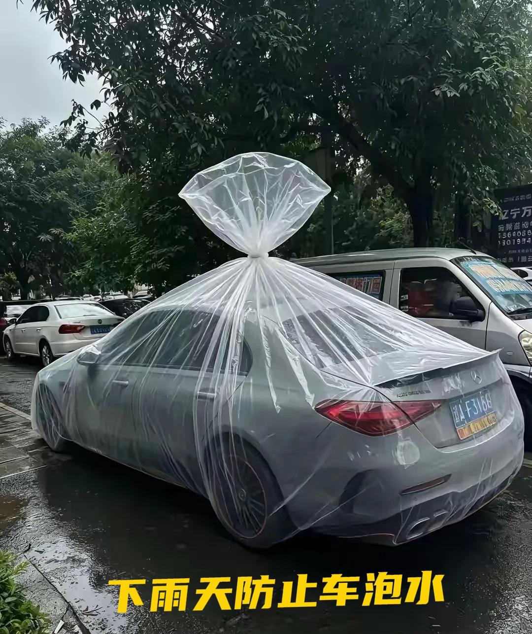 暴雨时给爱车套塑料布可行吗看！车主真是个奇才，把爱车打包，就不怕下大雨了！下雨天