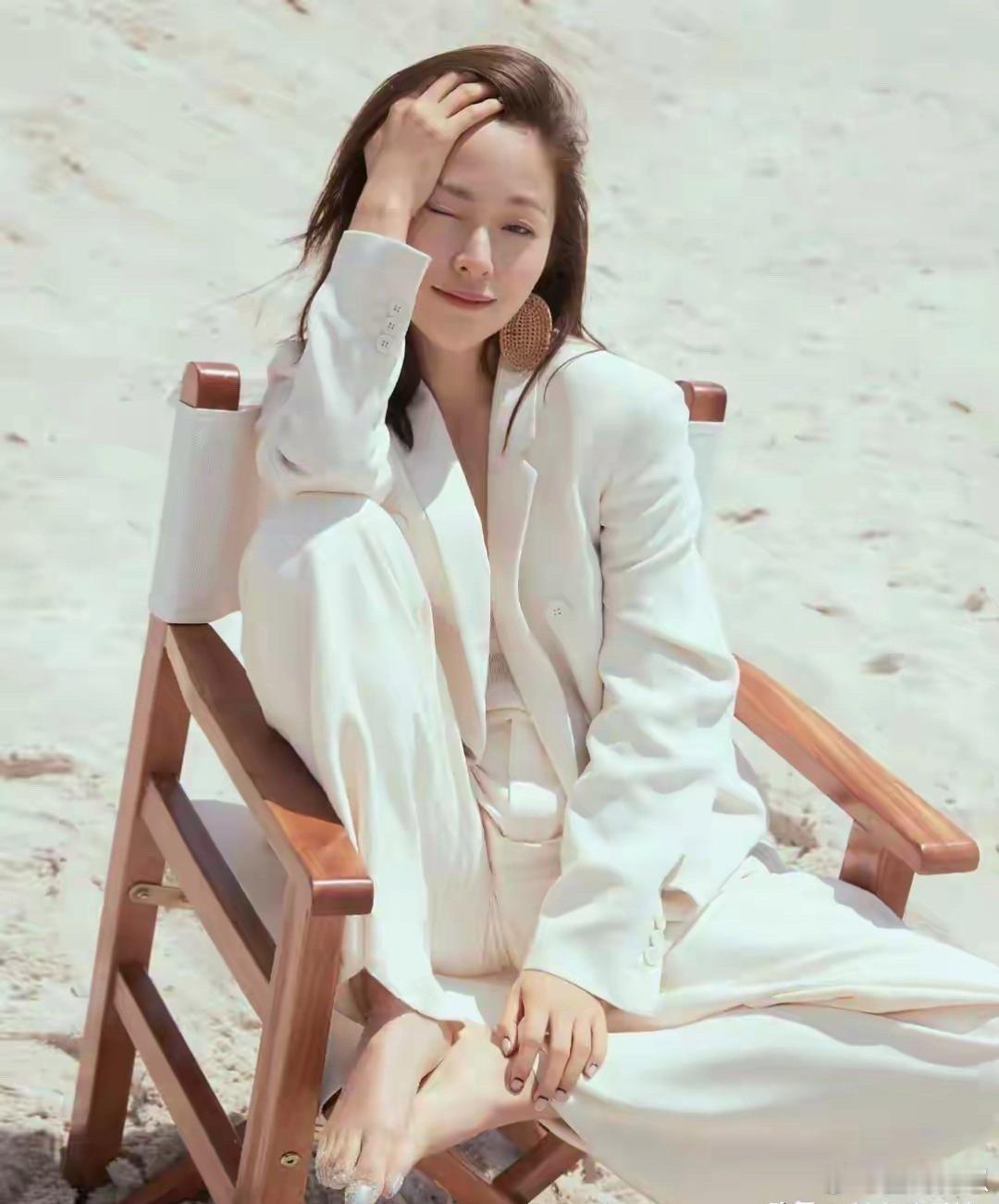 江一燕赤脚搭配黑色吊带裙，姿态优雅又松弛，浅浅一笑格外动人。 