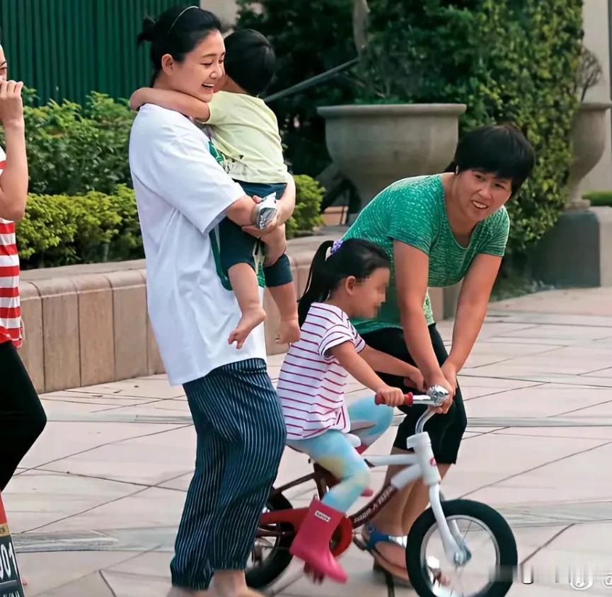 ​小杨阿姨在教玥儿骑自行车，大S就在旁边一边注意玥儿的安全，一边抱着霖霖。
​看