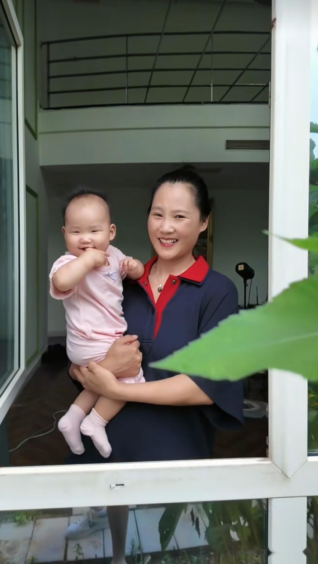 耿为华老师的妻子抱着二宝看爸爸在地里摘西红柿和黄瓜，小宝贝都长这么大了，她和妈妈