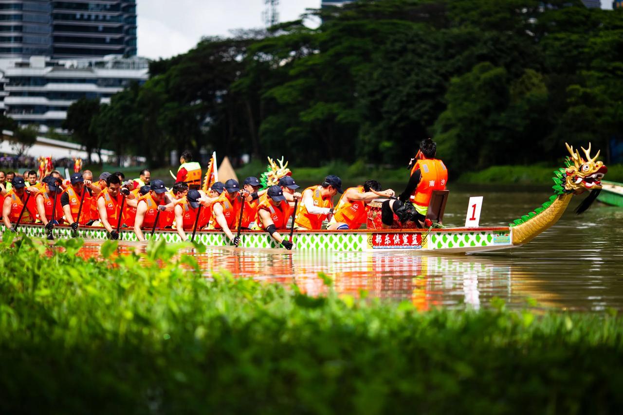  广州南沙扒龙舟的组织者真是猪头，河边本来都是树，还将隔离带搞那么远，看都看不到