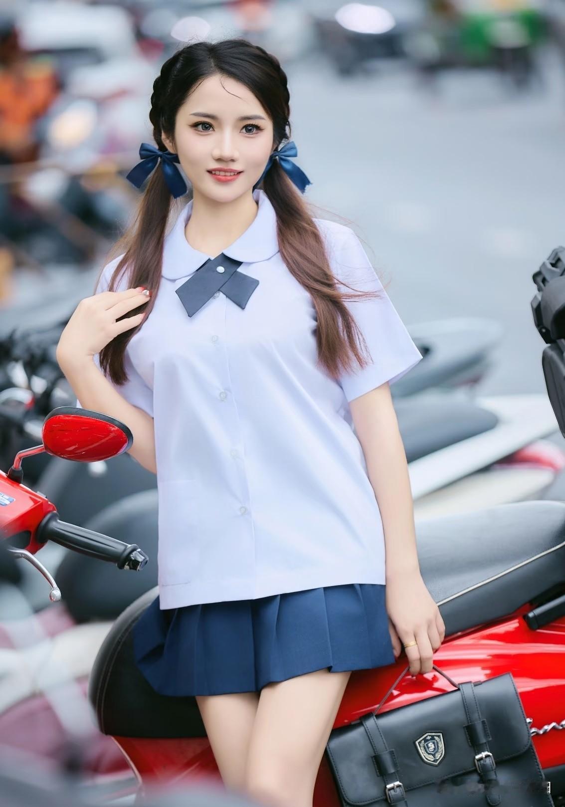 一个穿校服的妹子靠在摩托车上。