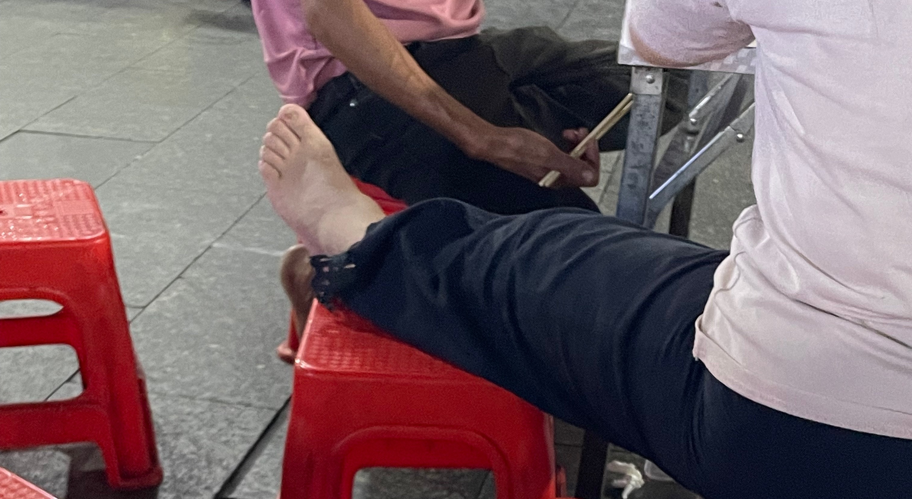 近日，玉林博白夜市一阿姨鞋子脱了脚伸到凳子上。这种行为非常的不文明啊！  ​​​