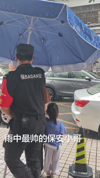 这个学校门口的保安小哥看起来很有爱心。
大雨天他还拿来遮阳伞给没有带雨具的孩子家
