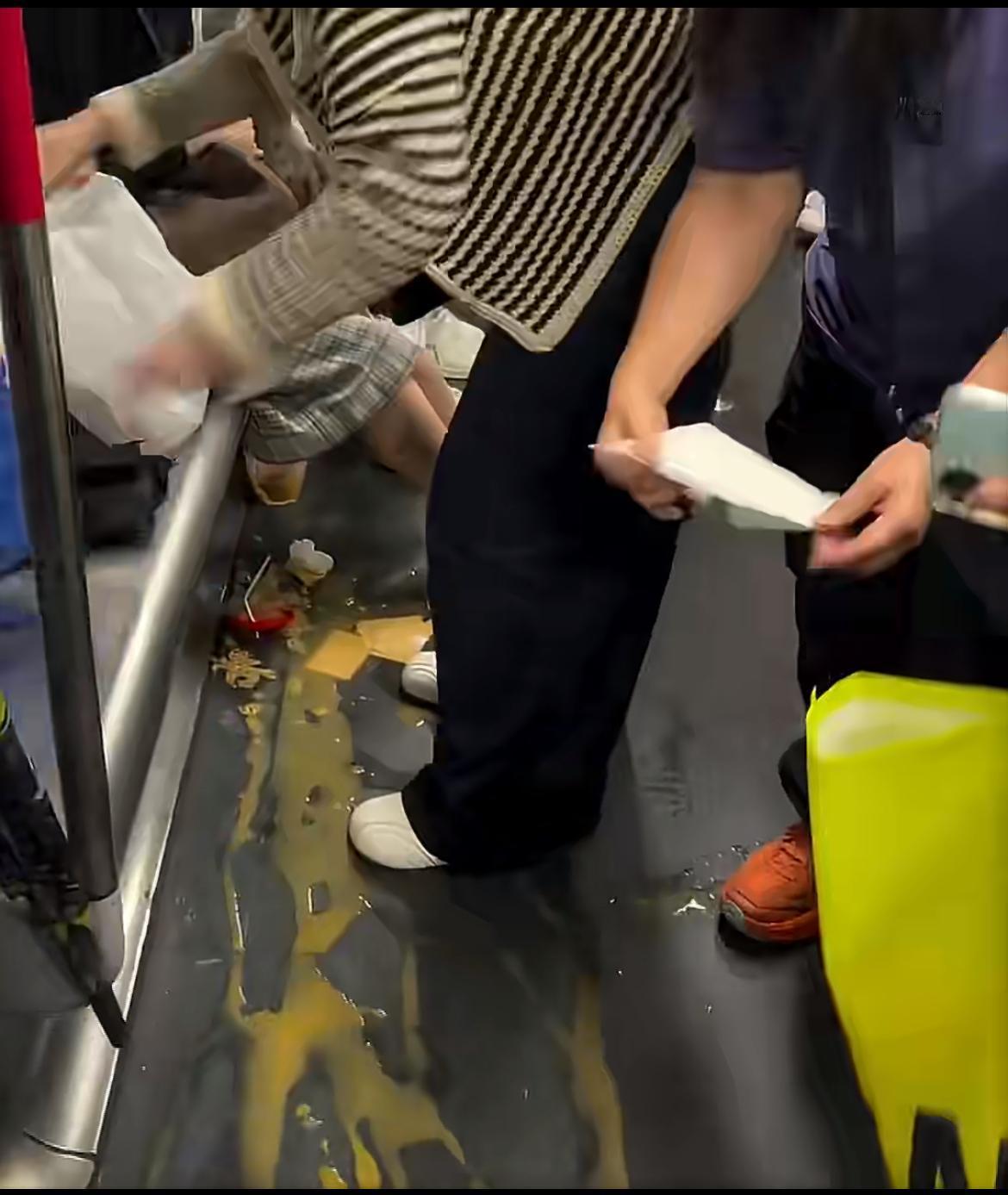 劳动节期间，大陆乘客在香港地铁不小心弄翻饮料，她立马翻包找纸巾清理，周围乘客也纷