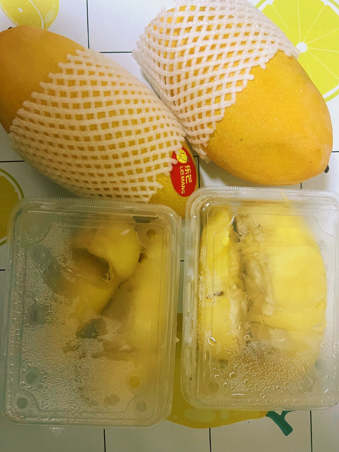 在大街上捡了一袋水果，它在雨里面淋着，里面有两盒刚剥好的榴莲肉和两个巨大的芒果，