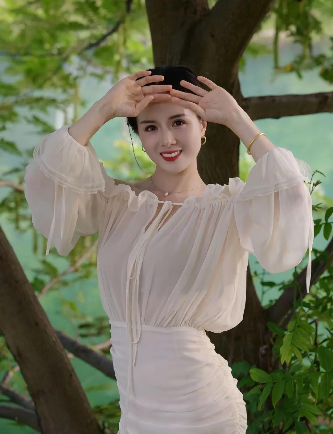 夏日清新穿搭，优雅白色连衣裙，自然绿意背景，甜美笑容，轻松自在。