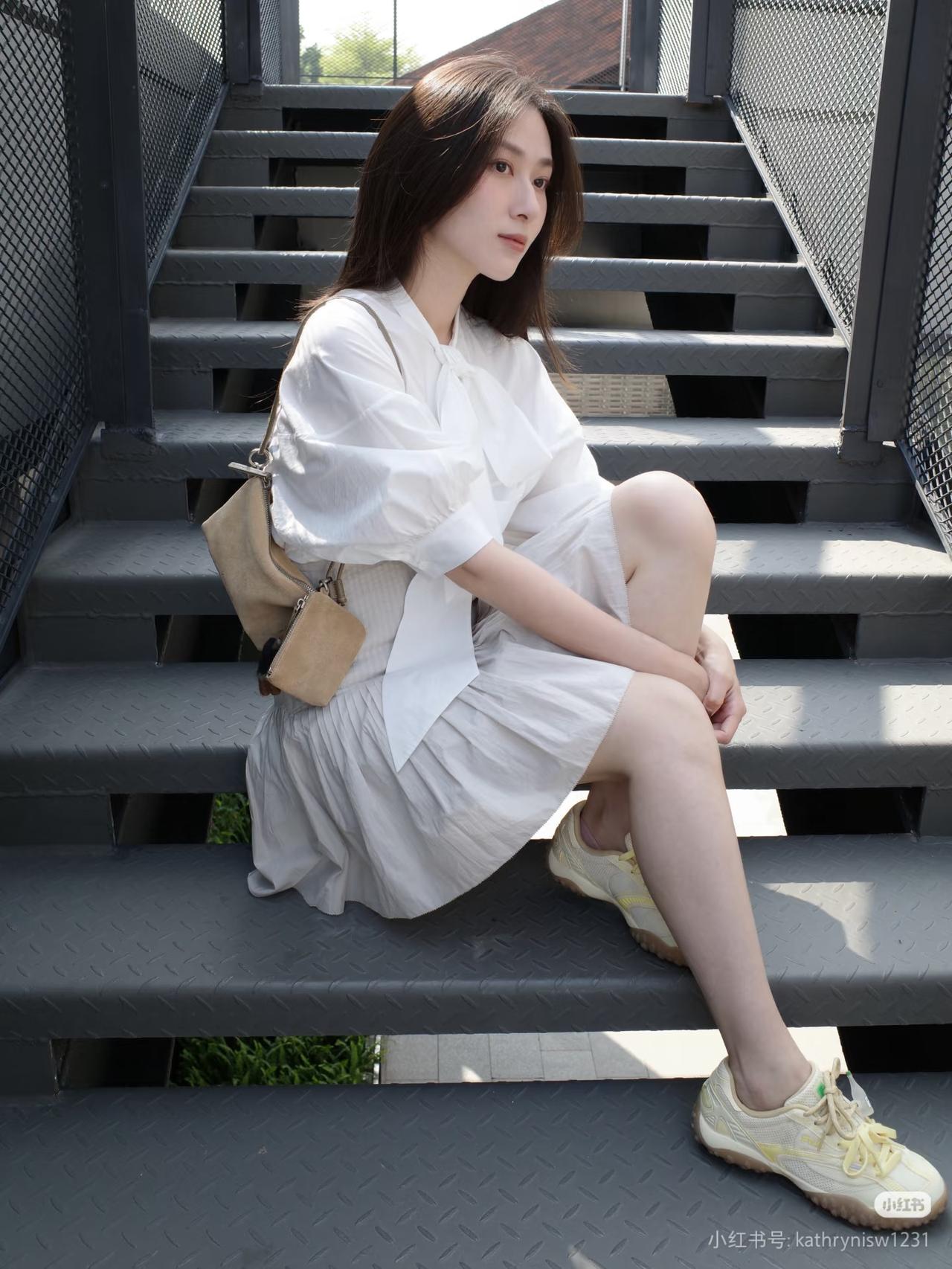 白衣少女坐台阶，轻风拂面意自闲。