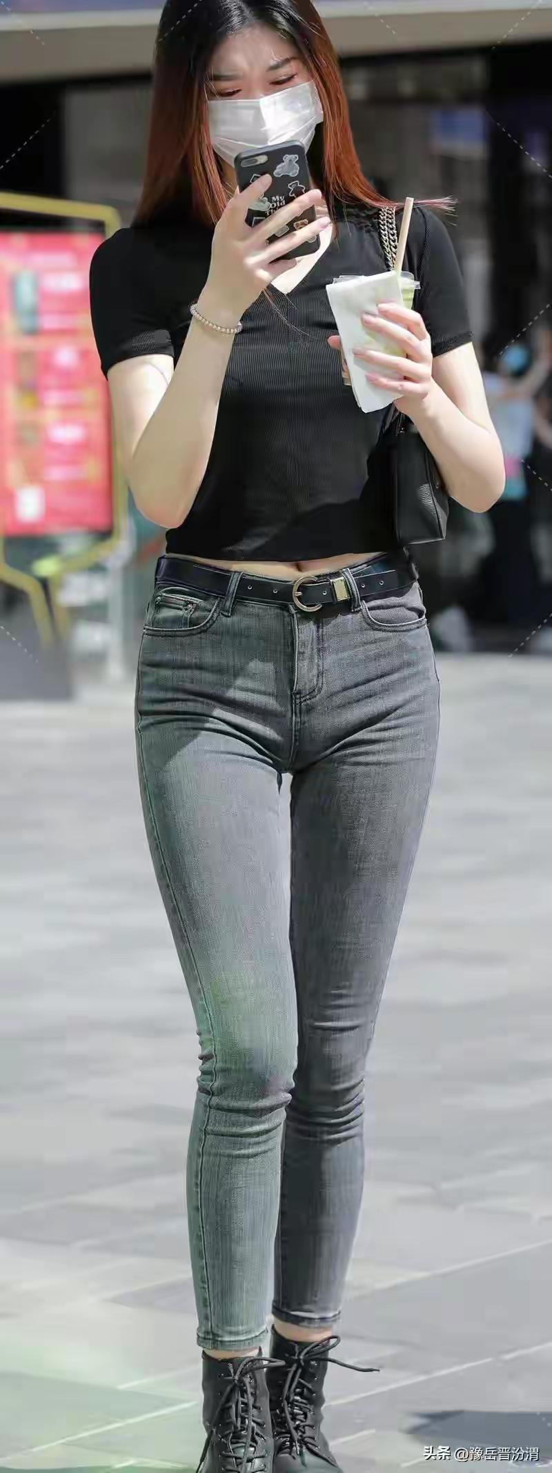 都市时尚女孩，黑T恤+牛仔裤，手拿奶茶，步履轻快