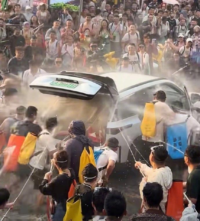 【女子被强拉开车门泼水车内部冒烟】太吓人了！西双版纳泼水节上，一群人直接强行拉开