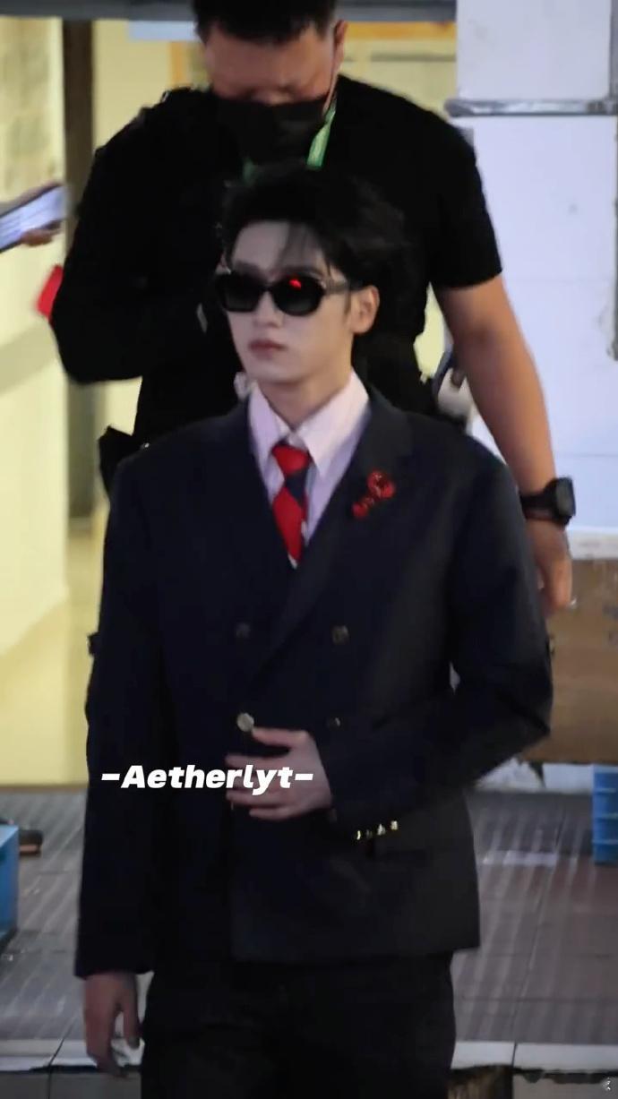 严浩翔像是去结婚的巅录制路透来袭，严浩翔一身礼服感藏蓝西装，红领带搭配小龙虾胸针