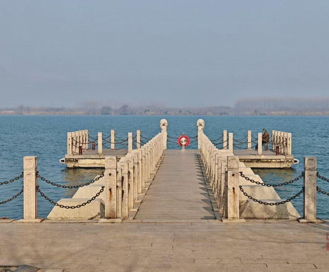 ✨江雾把远岸晕成朦胧的画，石栏牵着影子往水深处走，那抹救生圈的红，是寂静里跳脱的