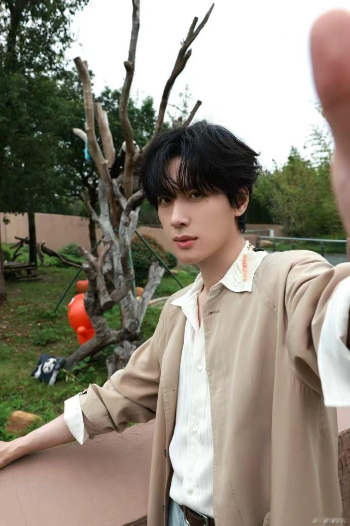 展轩和熊猫自拍 ​展轩和熊猫自拍，就这个展轩萌啊，和熊猫比耶自拍，户外风衣loo